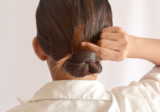 Back image of a girl holding her hairs