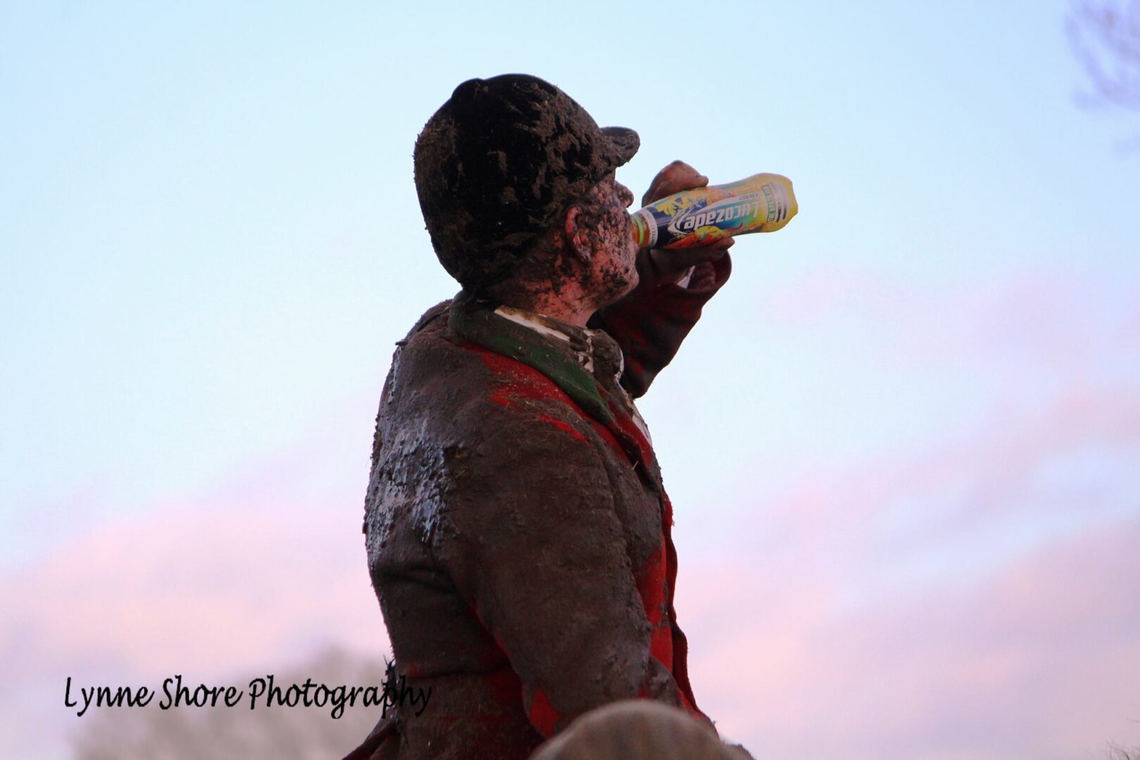 Man with dirty cloths drinking a bottle of water