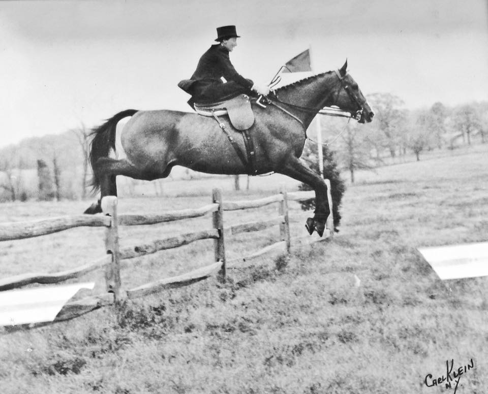 Black and white image of a man riding a horse