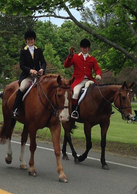 Two jockey riders running their horse on the street