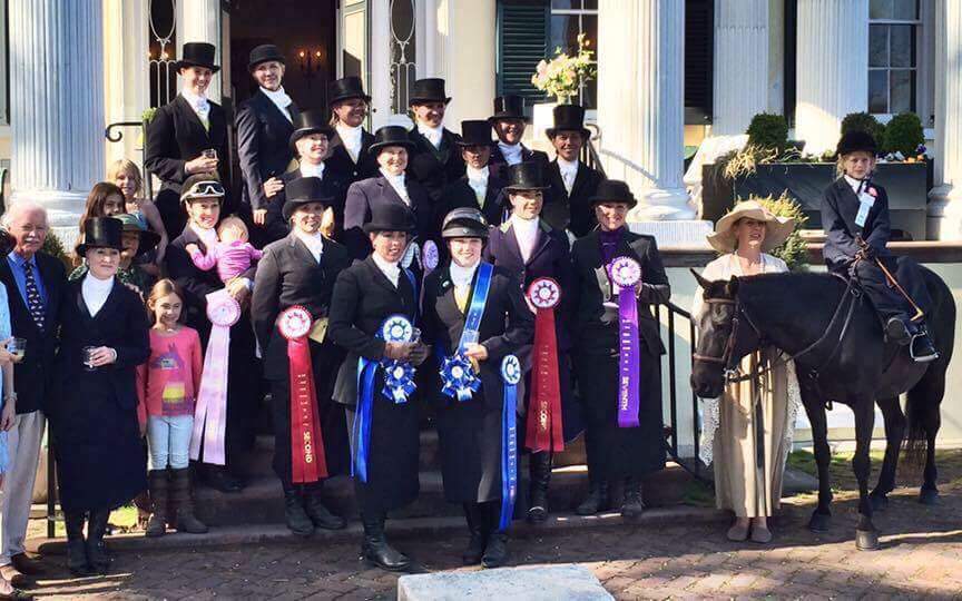 A group of equestrians posing for a photo.