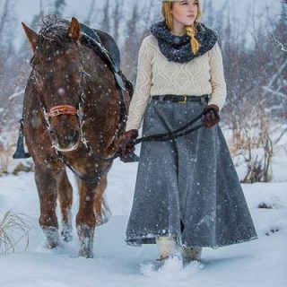 A small girl in snow with a horse